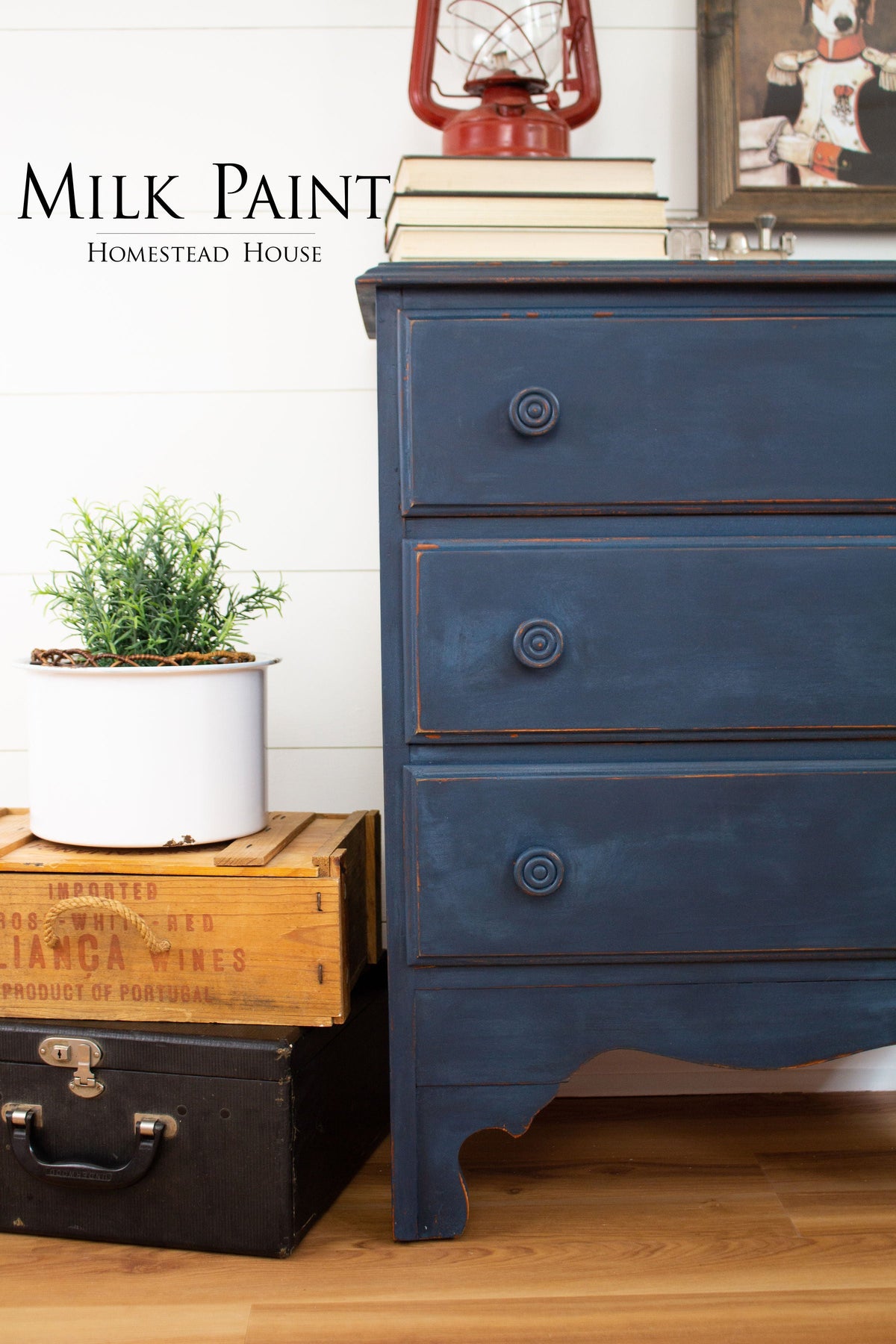 Dresser in Homestead House Liberty Blue Milk Paint with potted plant, books, and red lantern on wood floor.