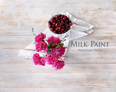 Limestone Milk Paint by Homestead House text on wood, with cherries and pink flowers on white cloth.