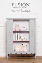 Gray matte cabinet with shelves, shown against a white wood wall in Fusion Mineral Paint’s Little Lamb shade.
