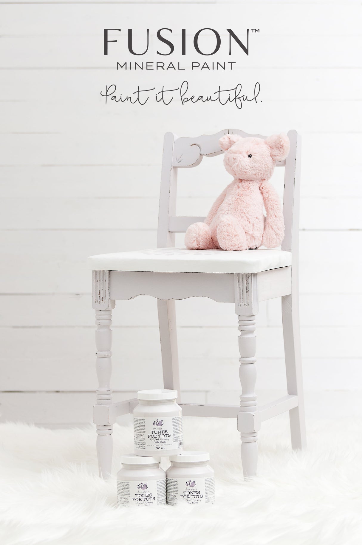 Light gray chair with a pink plush pig and three Little Stork Fusion Mineral Paint jars on a white fur rug.