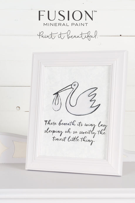 Little Stork Mineral Paint by Fusion, limited release, displayed on white shelf next to framed stork quote.