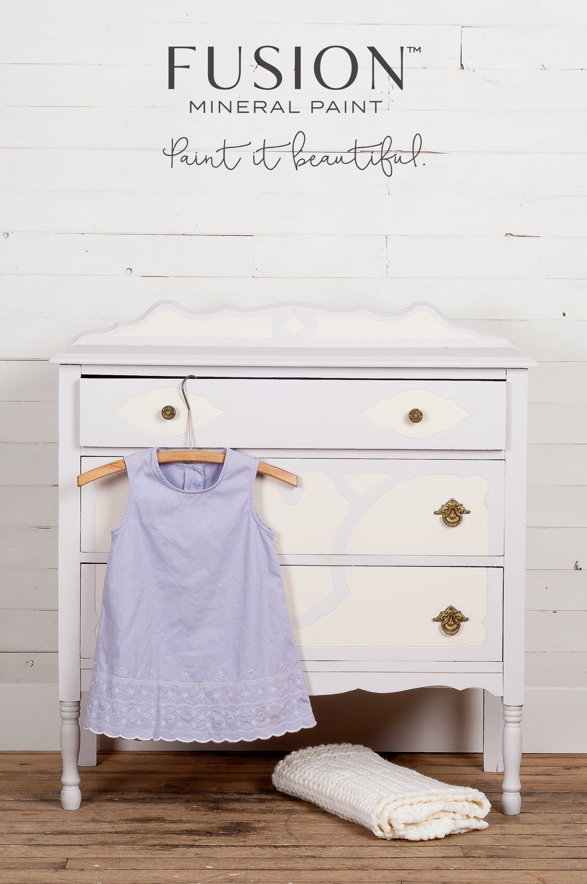 White vintage dresser with gold handles, painted in Fusion’s Little Stork, shown with lavender dress and blanket.
