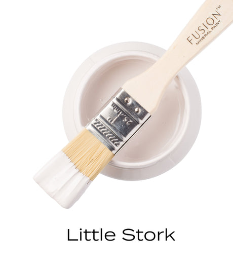 Brush with white paint on open Little Stork Mineral Paint jar by Fusion Mineral Paint (Limited Release).