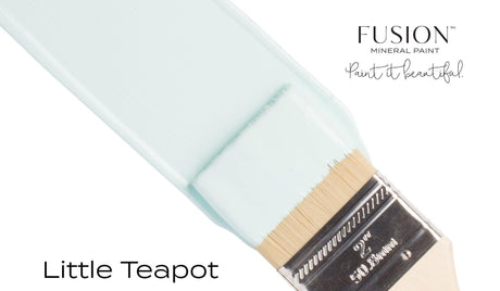 Brush with teal “Little Teapot Fusion Mineral Paint (Seasonal)” by Fusion Mineral Paint against a white background.