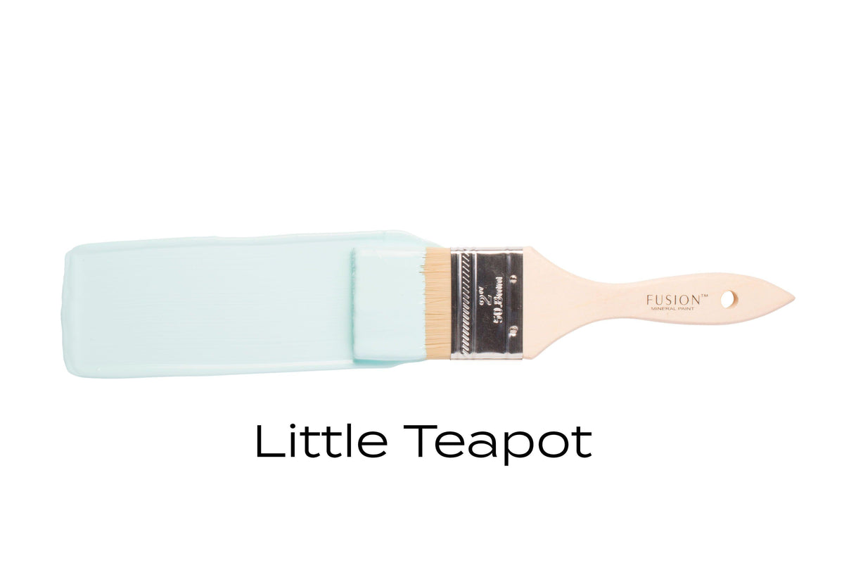 Paintbrush with teal bristles, labeled Little Teapot Fusion Mineral Paint by Fusion Mineral Paint below.