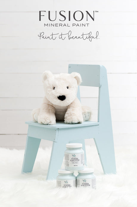 White stuffed bear on chair with Little Whale Fusion Mineral Paint jars on a white furry rug below.