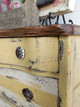 Distressed yellow dresser in Love Bug by Old Fashioned Milk Paint, featuring vintage drawer handles.