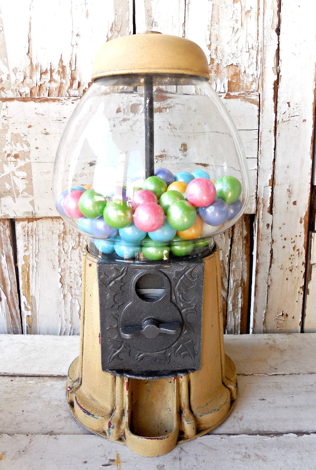 Vintage gumball machine in front of wood painted with Old Fashioned Milk Paint Love Bug red.