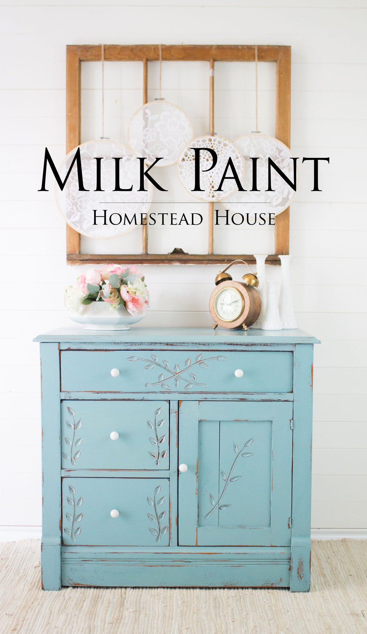 Blue cabinet with floral carvings, white knobs, and “Loyalist Milk Paint by Homestead House” above the clock.