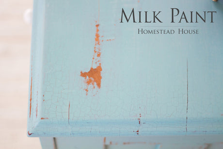 Chipped Loyalist Milk Paint by Homestead House on wood, with “Homestead House Milk Paint” text.