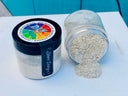 Two jars of Making Powder by DIY Paint Co., one tipped and spilling silver powder onto a white surface.
