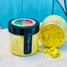 Two Making Powder jars by DIY Paint Co.; one jar open and spilled on a wooden surface.
