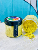 Two Making Powder jars by DIY Paint Co.; one jar open and spilled on a wooden surface.