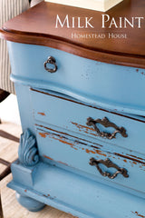 Vintage dresser with Maritime Blue Milk Paint by Homestead House, ornate handles, and chipped blue finish.