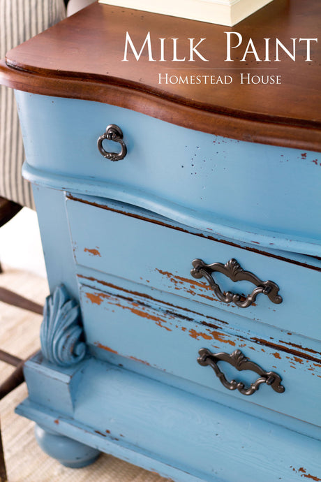 Vintage dresser with Maritime Blue Milk Paint by Homestead House, ornate handles, and chipped blue finish.