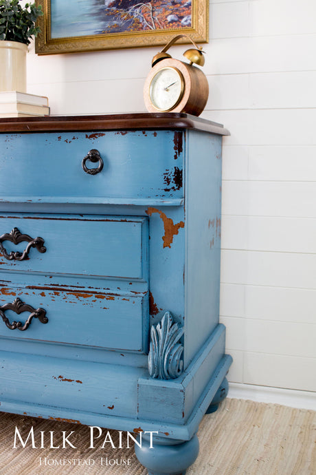 Blue wooden dresser in Homestead House Maritime Blue Milk Paint with ornate handles.