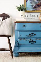 Homestead House dresser in Maritime Blue Milk Paint next to a wooden chair and green plant.