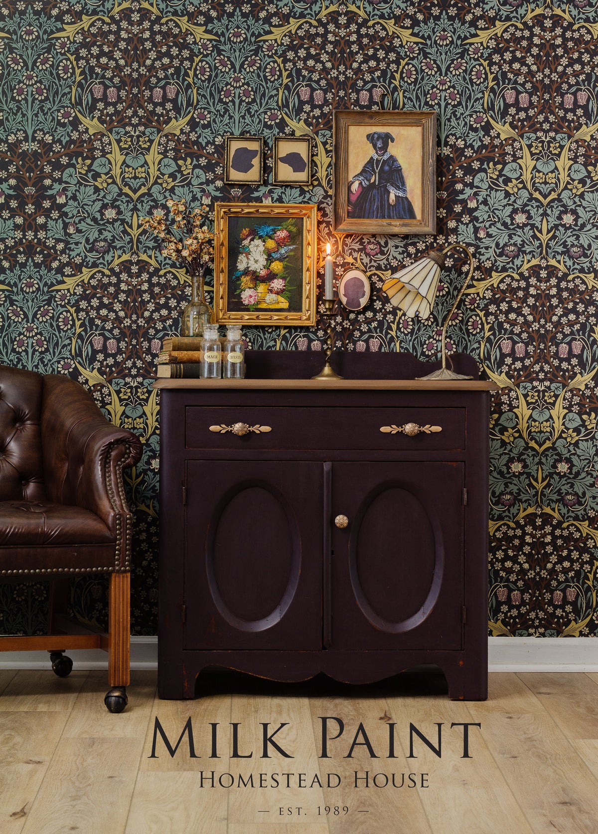 Dark wood cabinet with vintage decor and leather chair, featuring Mennonite Red by Homestead House against floral wallpaper.