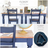Two navy blue chairs with a wooden desk painted in Fusion Mineral Paint Midnight Blue, styled with books and a globe.