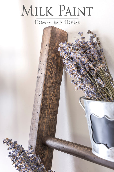 A pail of dried lavender placed on a wooden ladder, used to display Fusion Mineral Paint’s Milk Paint Wood Stain.