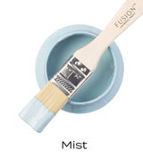 Open Mist Fusion Mineral Paint jar, periwinkle matte finish, with paintbrush resting on top and label reading “Mist.”.