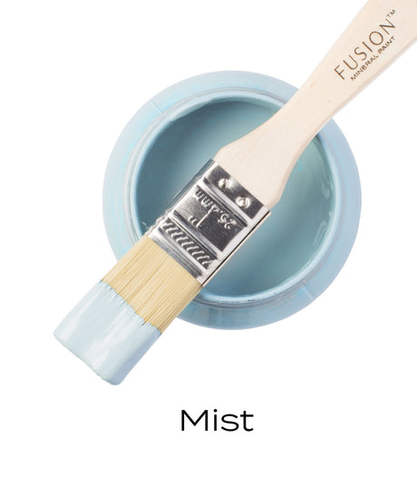 Open Mist Fusion Mineral Paint jar, periwinkle matte finish, with paintbrush resting on top and label reading “Mist.”.