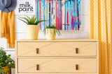 Yellow dresser painted with Fusion Mod Mustard Milk Paint, shown near plants, art, and yellow curtains.
