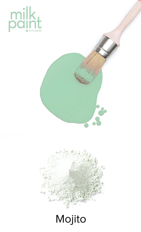 Paintbrush with Mojito Milk Paint by Fusion Mineral Paint and green powder on white background.