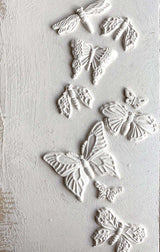 Embossed butterflies and moths created with Monarch Mould by IOD on a textured white background.