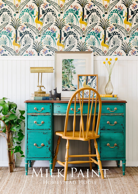 Teal desk painted with Montclair Milk Paint by Homestead House, paired with wood chair and lamp.