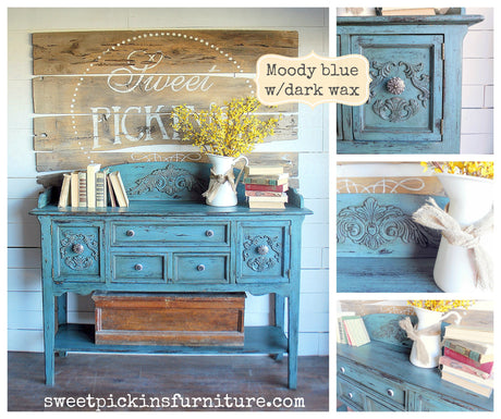 Blue sideboard painted in Moody Blue by Old Fashioned Milk Paint with yellow flowers, books, and rustic decor on top.