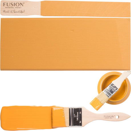 Paintbrush with Mustard Fusion Mineral Paint, painted swatch, and Fusion Mineral Paint can displayed together.