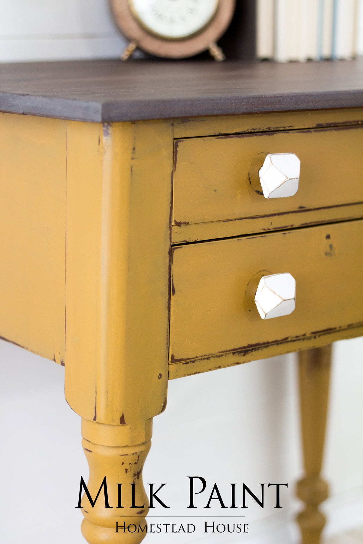 Yellow wooden desk with two drawers, white geometric knobs, finished in Homestead House Mustard Milk Paint.