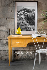 Yellow Mustard Milk Paint desk by Homestead House with drawer, photo, pear decor, and white chair.