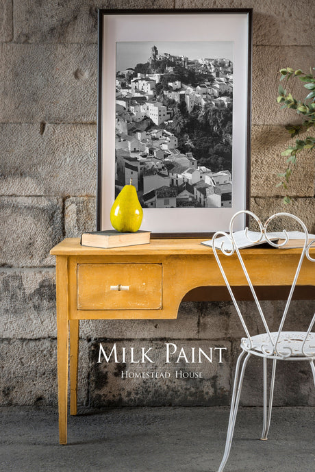 Yellow Mustard Milk Paint desk by Homestead House with drawer, photo, pear decor, and white chair.