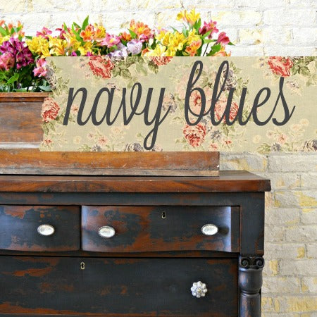 Dark wooden dresser painted Navy Blues by Old Fashioned Milk Paint, topped with flowers.