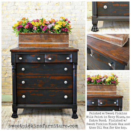 Navy Blues dresser by Old Fashioned Milk Paint with white knobs, claw feet, and a tray of bright flowers on top.
