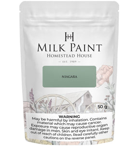 Homestead House Niagara Green Milk Paint 50g bag with floral design and visible cancer risk warning.
