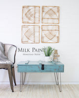 Table painted with Niagara Green Milk Paint by Homestead House placed beside a metal chair.