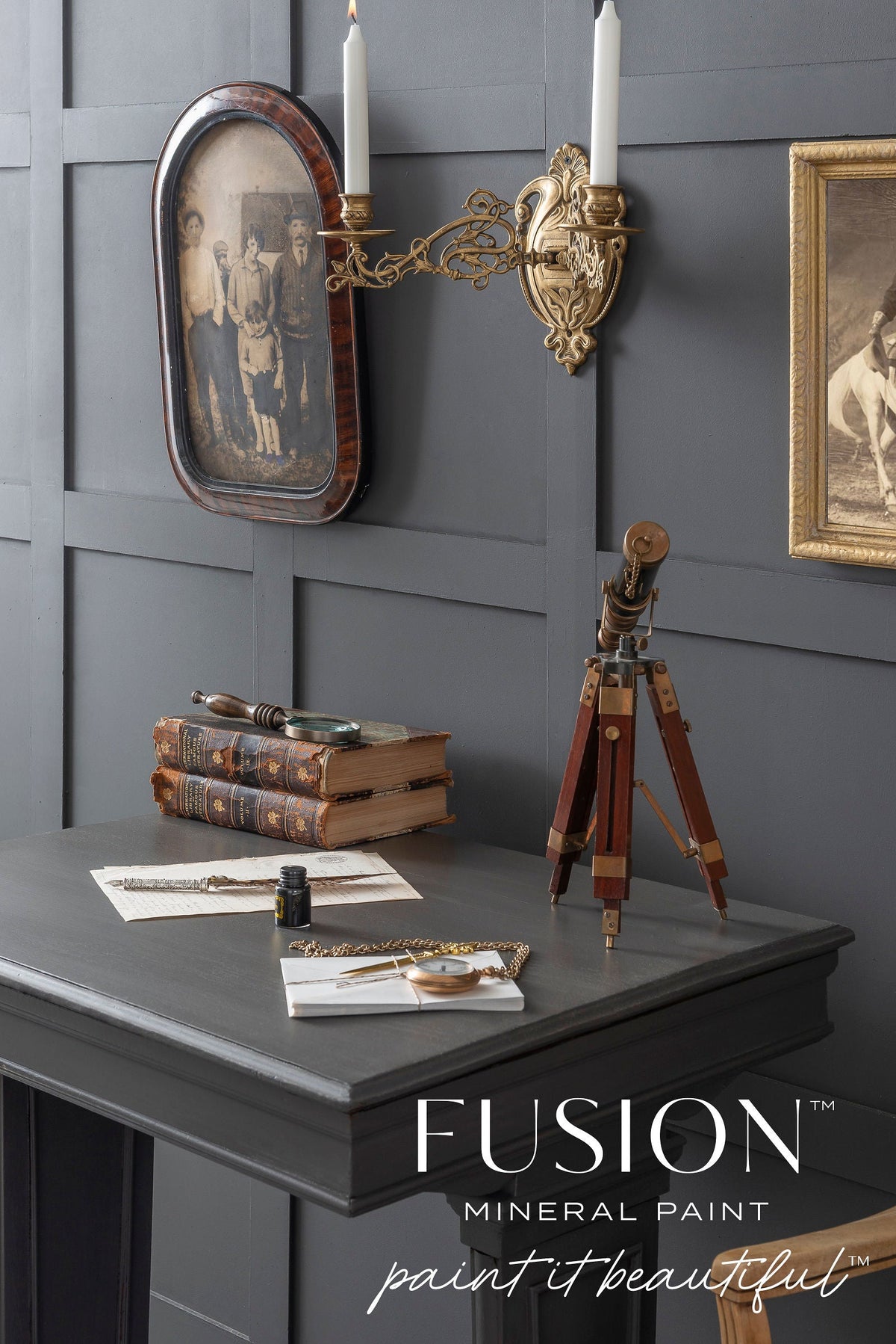Vintage desk with books, telescope, and sconce against a matte gray Oakham Fusion Mineral Paint wall.