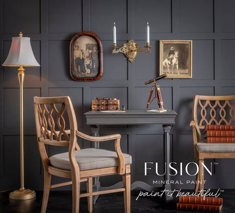 Oakham Fusion Mineral Paint by Fusion displayed on a matte-finish wall behind vintage chairs, books, and a telescope.