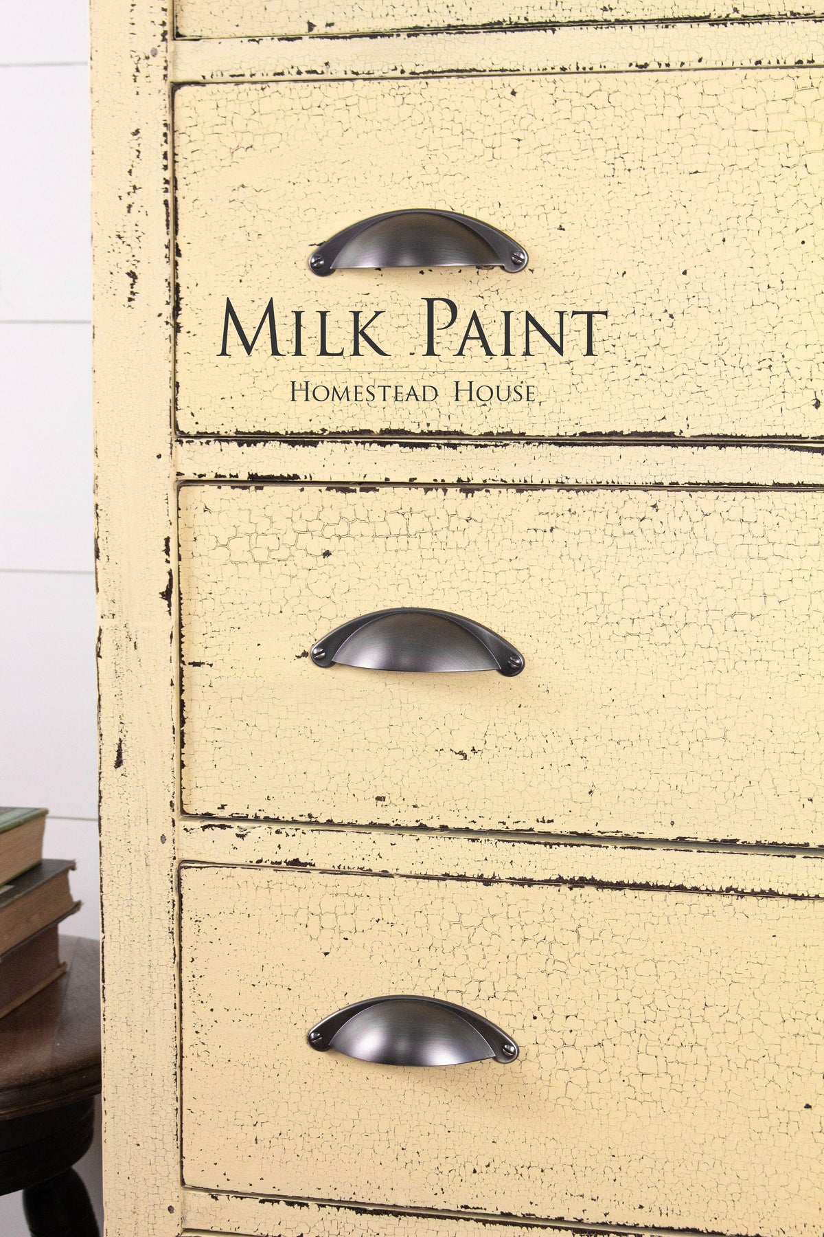 Distressed yellow dresser in Ochre Milk Paint by Homestead House, three metal handles, branded top drawer.