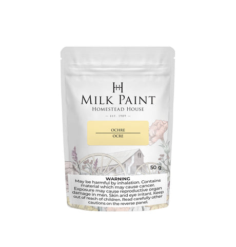 50g Homestead House Ochre Milk Paint pouch with floral and wagon art, plus a visible health warning label.