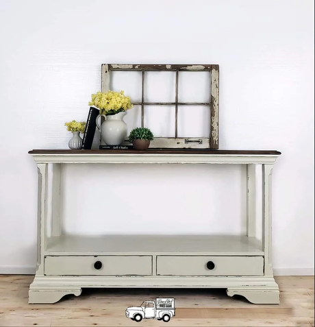 Cream console table with drawers, painted in Miss Lillian’s Old Cupboard No-Wax Chock Paint; books and yellow flowers on top.
