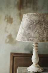 Textured-shade lamp in front of a wall featuring the Orléans Stamp by IOD - Iron Orchid Designs.