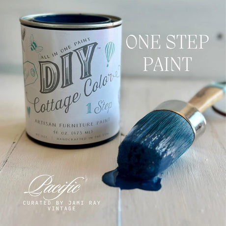 Pacific DIY Cottage Color by DIY Paint Co. can with blue brush on wood surface.