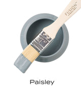 Brush with gray paint resting on open Fusion Mineral Paint Paisley jar.