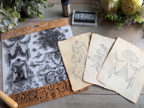 Palais des Fleurs Stamp by IOD on vintage-style papers displayed on a wooden table with flowers.