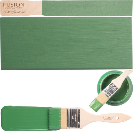 Wooden board with paintbrush and open jar of Park Bench Fusion Mineral Paint in green.