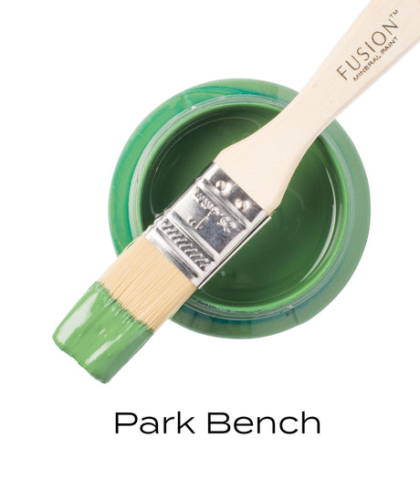 Brush with green Fusion Mineral Paint rests on open Park Bench jar labeled Fusion Mineral Paint.